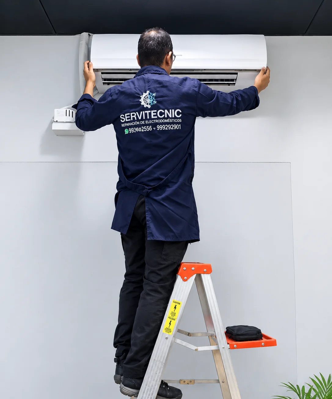 Técnico de Servitecnic instalando un equipo de aire acondicionado en el domicilio de un cliente